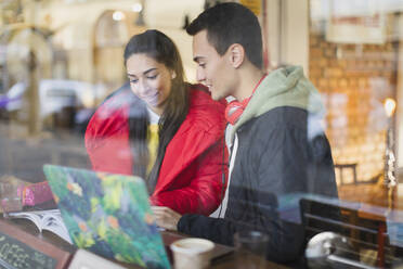 Junges Paar studiert am Fenster eines Cafés - CAIF26064