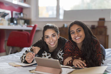 Porträt lächelnd zuversichtlich, jugendlich Mädchen Freunde studieren auf dem Bett - CAIF26116