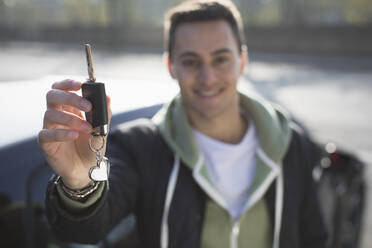Portrait smiling, confident young man with new car key - CAIF26131