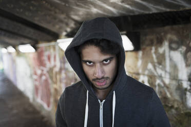 Portrait menacing young man in urban tunnel - CAIF26144