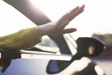 Carefree woman reaching hand out car window - CAIF26147