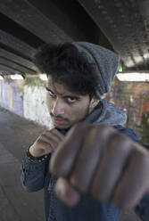 Porträt harter junger Mann beim Stanzen in einem städtischen Tunnel - CAIF26157