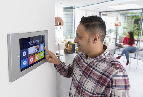 Mann stellt Touchscreen-Smart-Home-Alarm ein - CAIF26181