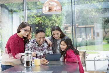 Glückliche Familie mit digitalem Tablet am Küchentisch - CAIF26182