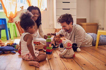 Young family playing with toys on floor - CAIF26228