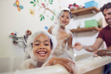 Portrait playful girls taking bubble bath - CAIF26229