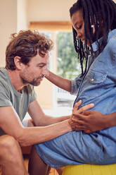Zärtlicher Ehemann berührt den schwangeren Bauch seiner Frau - CAIF26240