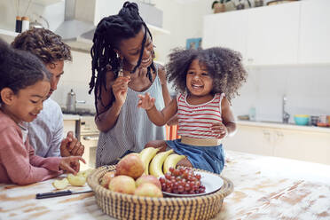 Junge Familie isst Obst in der Küche - CAIF26243