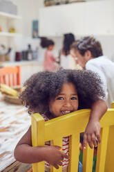 Portrait cute girl on yellow chair - CAIF26247