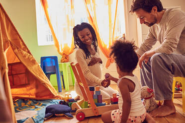 Pregnant young family playing with toys - CAIF26250