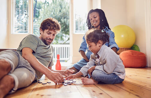 Junge Familie spielt mit Dominosteinen auf dem Boden - CAIF26252