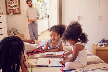 Young family coloring on bed - CAIF26263