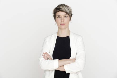 Portrait of woman with dyed short hair against white background - FLLF00445