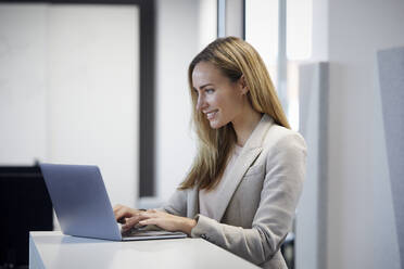 Geschäftsfrau mit Laptop im Büro - RBF07459