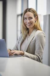 Geschäftsfrau mit Laptop im Büro - RBF07462