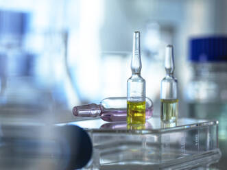 Close-up of various pharmaceutical vials standing in laboratory - ABRF00720