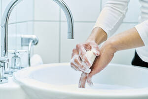 Woman washing her hand with soap - DIKF00411
