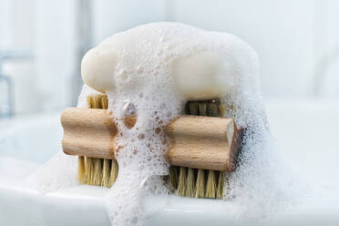 Soap, foam and brush on bathroom sink - DIKF00414