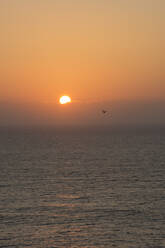 Portugal, Oeste, Alcobaca, Atlantic Ocean at moody orange sunset - FVSF00053