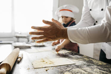 Vater mit Tochter bei der Zubereitung von Teig für selbstgemachte glutenfreie Nudeln in der Küche zu Hause - JRFF04291