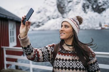 Tourist taking a selfie at the coast, Lofoten, Norway - MPPF00714