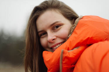 Portrait of young woman smiling outdoors - CAVF78165