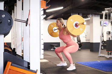 Eine starke, sportliche Frau, die mit Gewichten trainiert. - CAVF78385