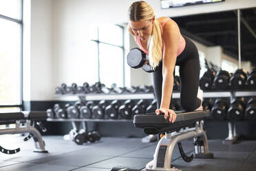 Eine blonde Frau trainiert in einem Fitnessstudio. - CAVF78391