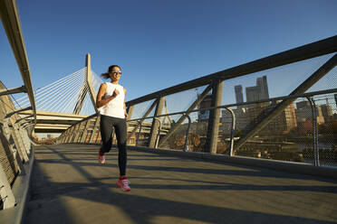 Ein Bostoner Läufer läuft auf einer Fußgängerbrücke in der Nähe der Zakim-Brücke. - CAVF78404