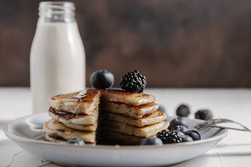 Still life of a stack of homemade pancakes with berries and syru - CAVF78575