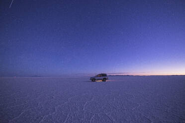 Fahrzeug auf dem Salar de Uyuni bei Sonnenuntergang - CAVF78613