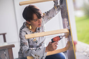 Upcycling young woman on a terrace - CAVF78676