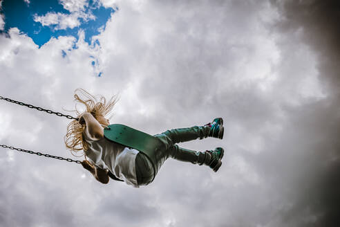 Girl on a swing on a cloudy day - CAVF78697