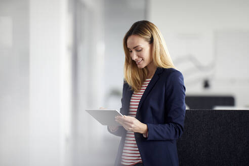 Geschäftsfrau benutzt Tablet im Büro - RBF07469