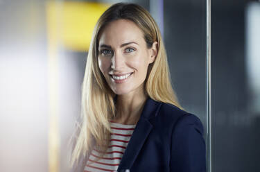 Portrait of smiling businesswoman in office - RBF07473