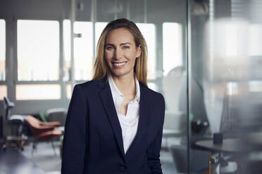 Portrait of smiling businesswoman in office - RBF07513