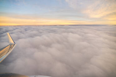 Blick aus dem Flugzeug bei Sonnenaufgang über den Wolken in Valencia - CAVF78803