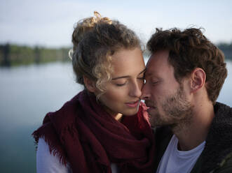 Romantisches Paar küsst sich am See - PNEF02584