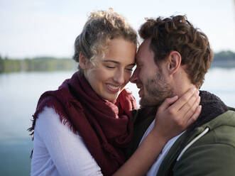 Romantioc couple kissing at lake - PNEF02586