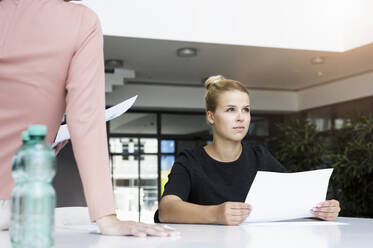 Geschäftsfrau mit Dokument und Kollege im Büro - BMOF00398