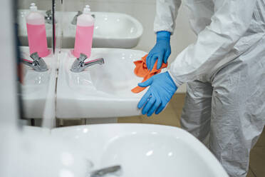 Cleaning staff desinfecting hospital against contageous virus, wearing protective clothing, close up - CJMF00296