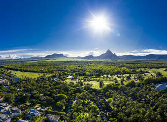 Mauritius, Black River, Flic-en-Flac, Luftaufnahme der Sonne über den Bäumen des Küstendorfs im Sommer - AMF07975