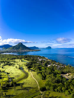 Mauritius, Black River, Flic-en-Flac, Luftaufnahme des blauen Himmels über dem Küstendorf im Sommer mit dem Berg Tourelle du Tamarin im fernen Hintergrund - AMF07976