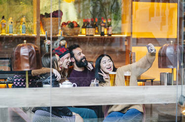 Freunde treffen sich in einer angesagten Bar und machen Smartphone-Selfies - DGOF00682