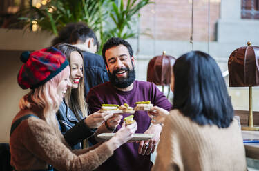 Friends meeting in a trendy bar, sharing starters - DGOF00685