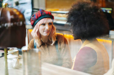 Zwei Freundinnen treffen sich in einem Café und trinken Tee - DGOF00692