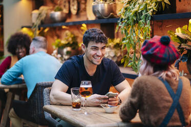 Man and woman having drinks in a restaurant - DGOF00751