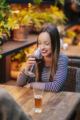 Young woman having a drink in a restaurant - DGOF00759