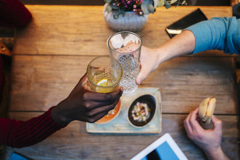 Zwei Menschen sitzen im Restaurant, essen und trinken, mit digitalem Tablet auf dem Tisch - DGOF00766