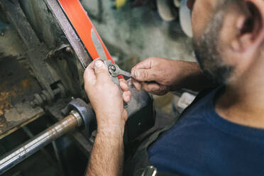 Handwerker bei der Herstellung von Messern in seiner Werkstatt - DGOF00788